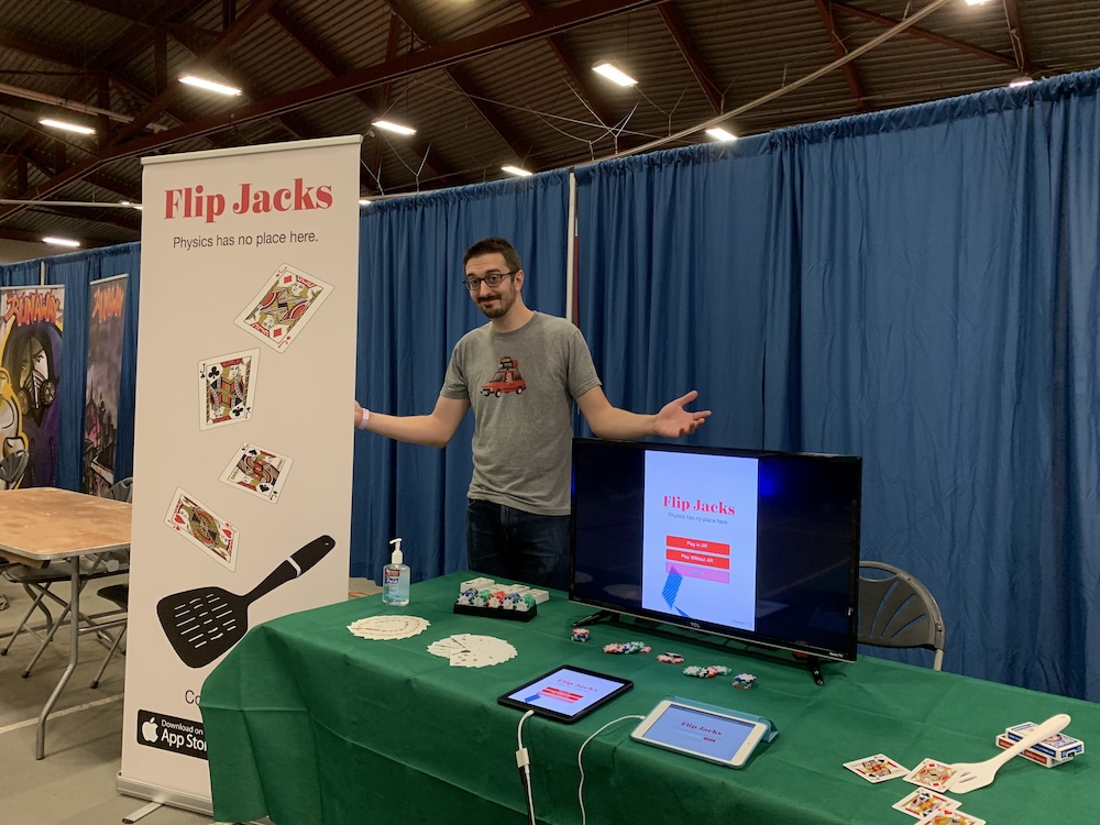 Picture of me standing at my booth at BostonFIG.